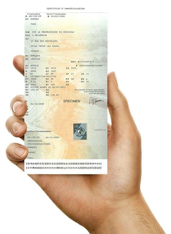 Certificat d'immatriculation français tenu en main